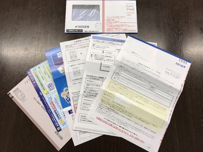SBI証券から届いた書類の数々。記入・返送を考えると、郵送だと手間に感じてしまいました。